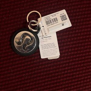 Lululemon logo keychain. Glare is due to protective cover still being on.